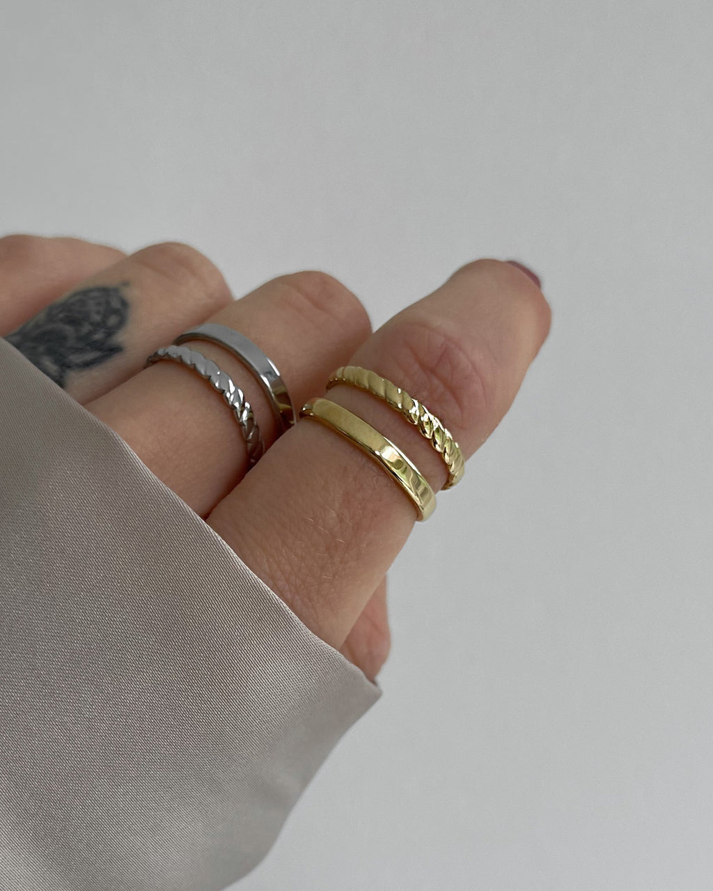 Doppellagiger, verstellbarer wasserfester Edelstahlring in gold und silber, getragen am Finger.