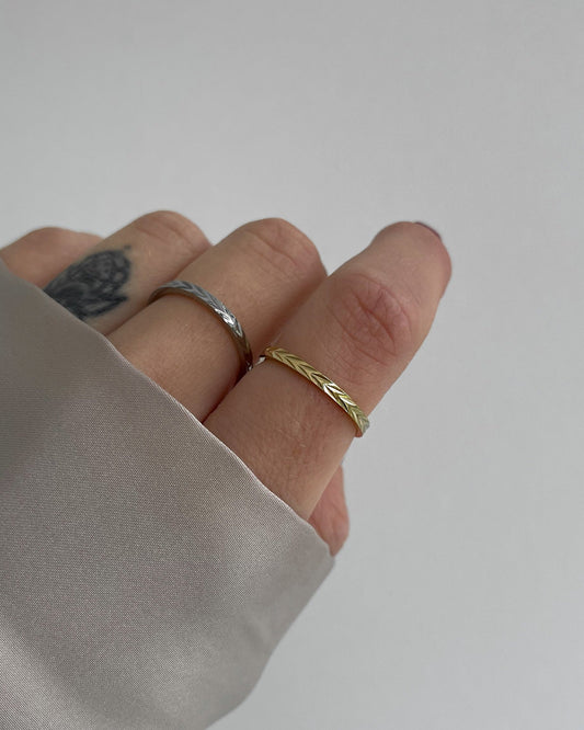 Verstellbarer, feiner Edelstahlring mit dezentem Muster., getragen am Finger.