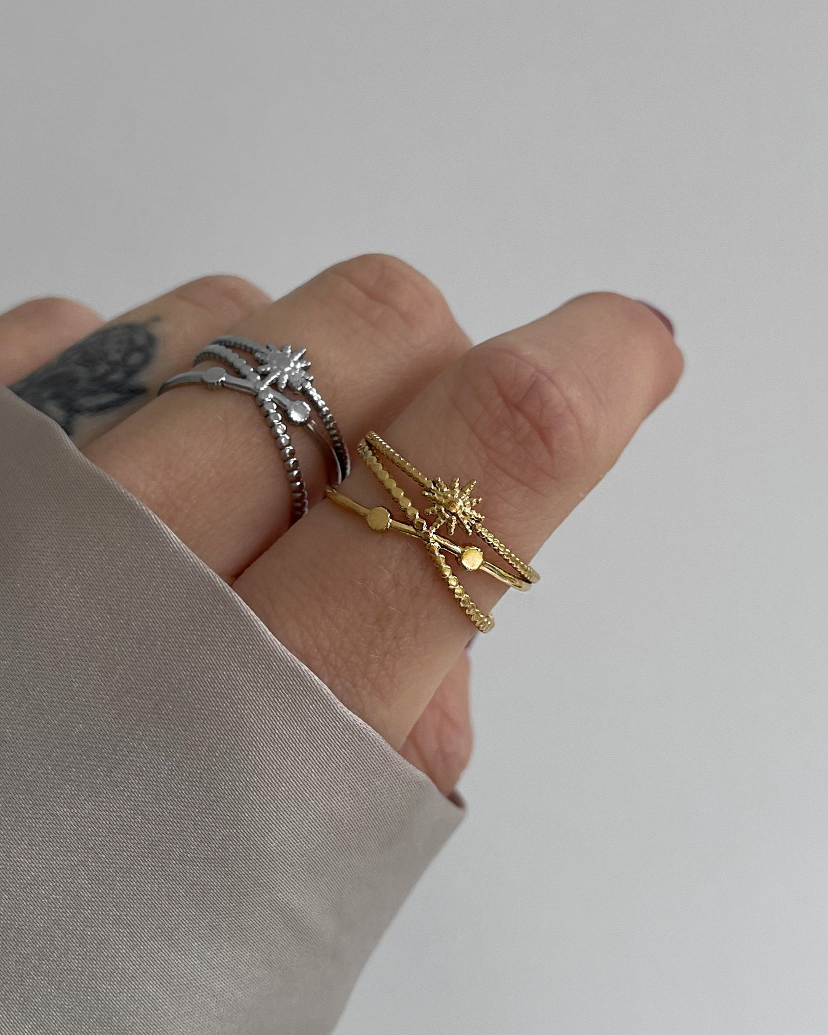 Wasserfester Edelstahl Ring mit Sonnendesign, größenverstellbar in gold und silber, getragen am Finger.