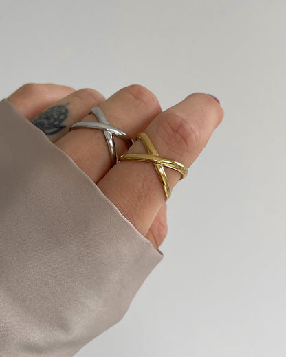 Wasserfester Edelstahl Ring mit gekreuztem Design in gold und silber a Finger getragen.