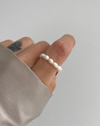 Süßwasserperlenring, elastisch, getragen am Finger.