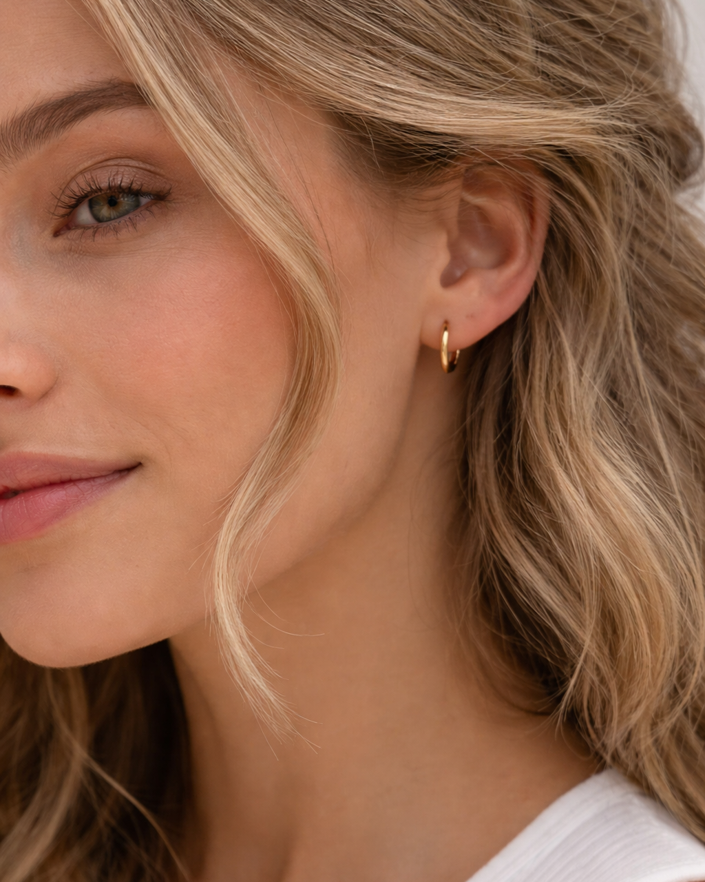 Kleine Edelstahl Creolen 1,2 cm am Ohr getragen in Gold