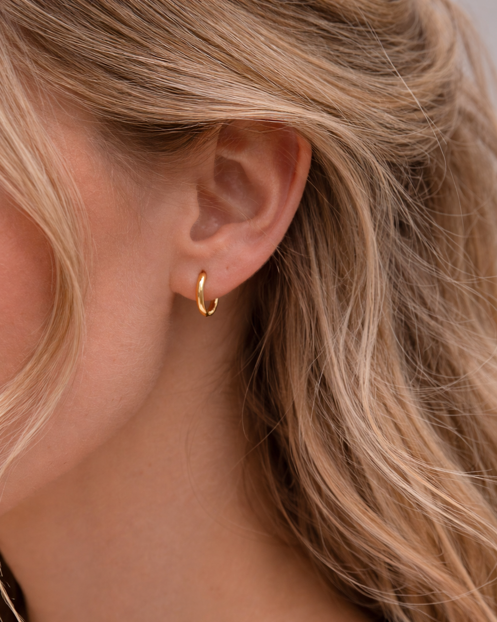 Kleine Edelstahl Creolen 1,2 cm am Ohr getragen in Gold