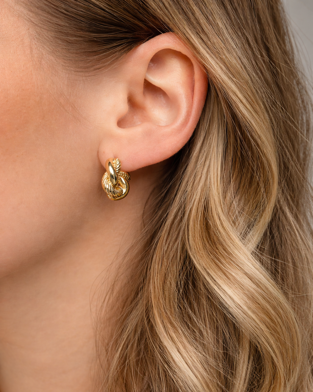 Gedrehte Gold Ohrringe Twister aus Edelstahl am Model im Close-up