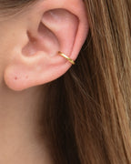 Feiner Edelstahl Earcuff in gold, getragen am Ohr.