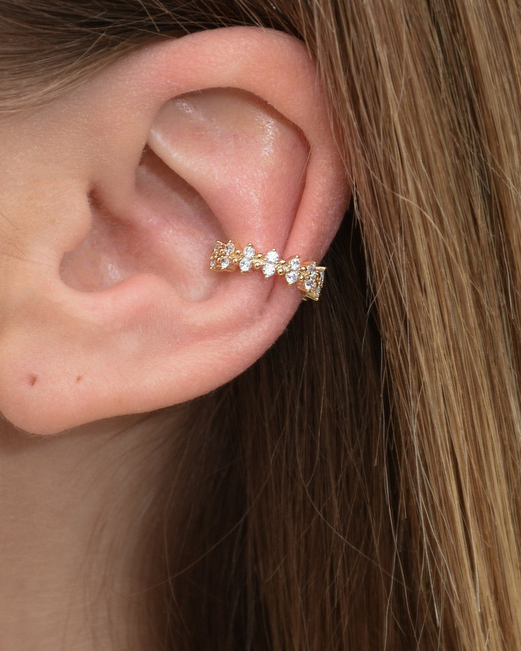Funkelnder Edelstahl Earcuff in gold getragen am Ohr.